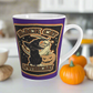 This 12 ounce ceramic glossy latte mug features Halloween distressed style print of a black cat wearing a witch's hat and says Black Cat Apothecary. There is a yellow moon and jack o'lantern.