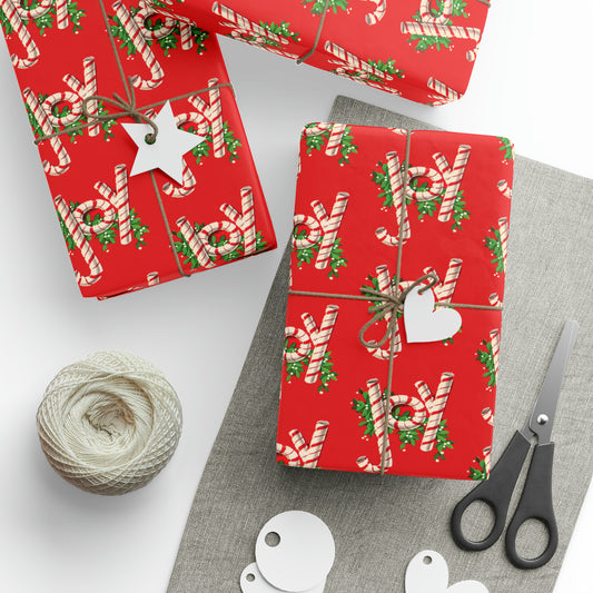 This retro vintage red Christmas wrapping paper features candy canes that spell out Joy with holly leaves behind them.