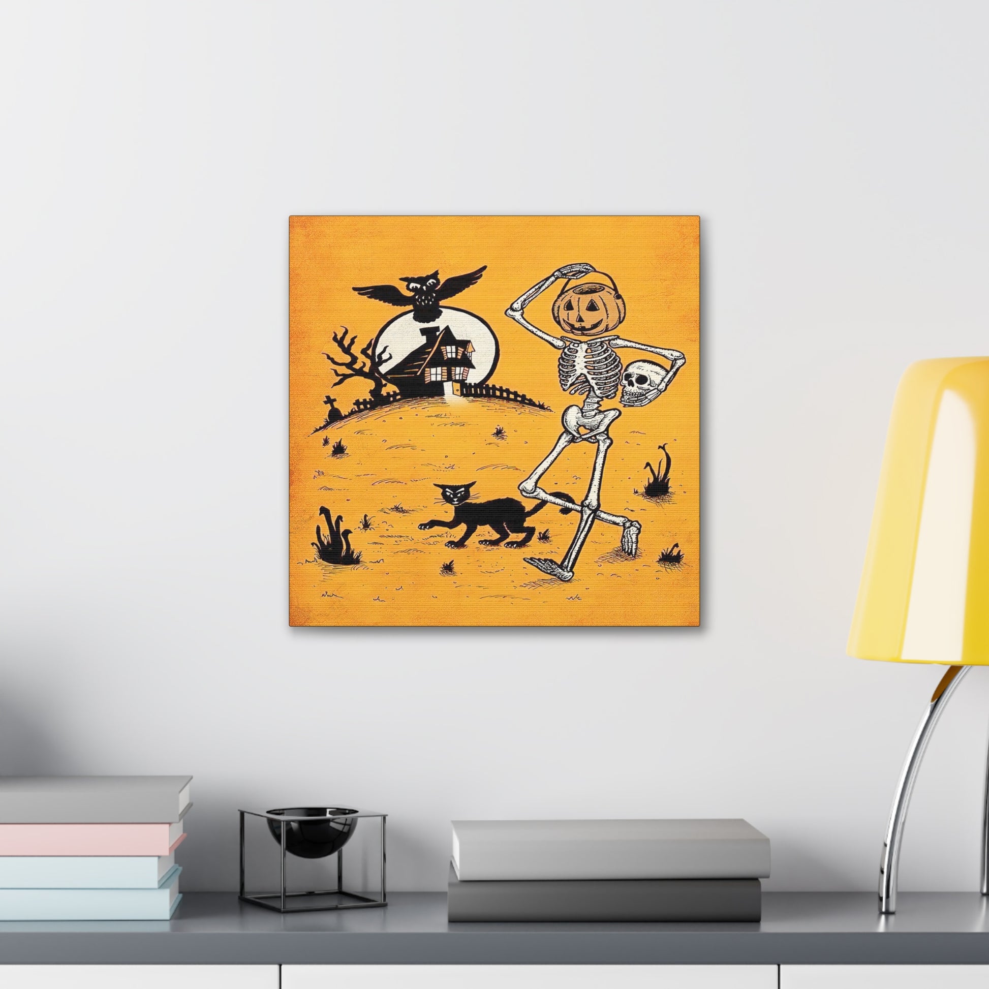 This canvas wall art features a retro vintage Halloween illustration of a skeleton with a trick or treating bucket for a head, a black cat, flying owl and spooky house with a full moon. The background is yellowish orange.