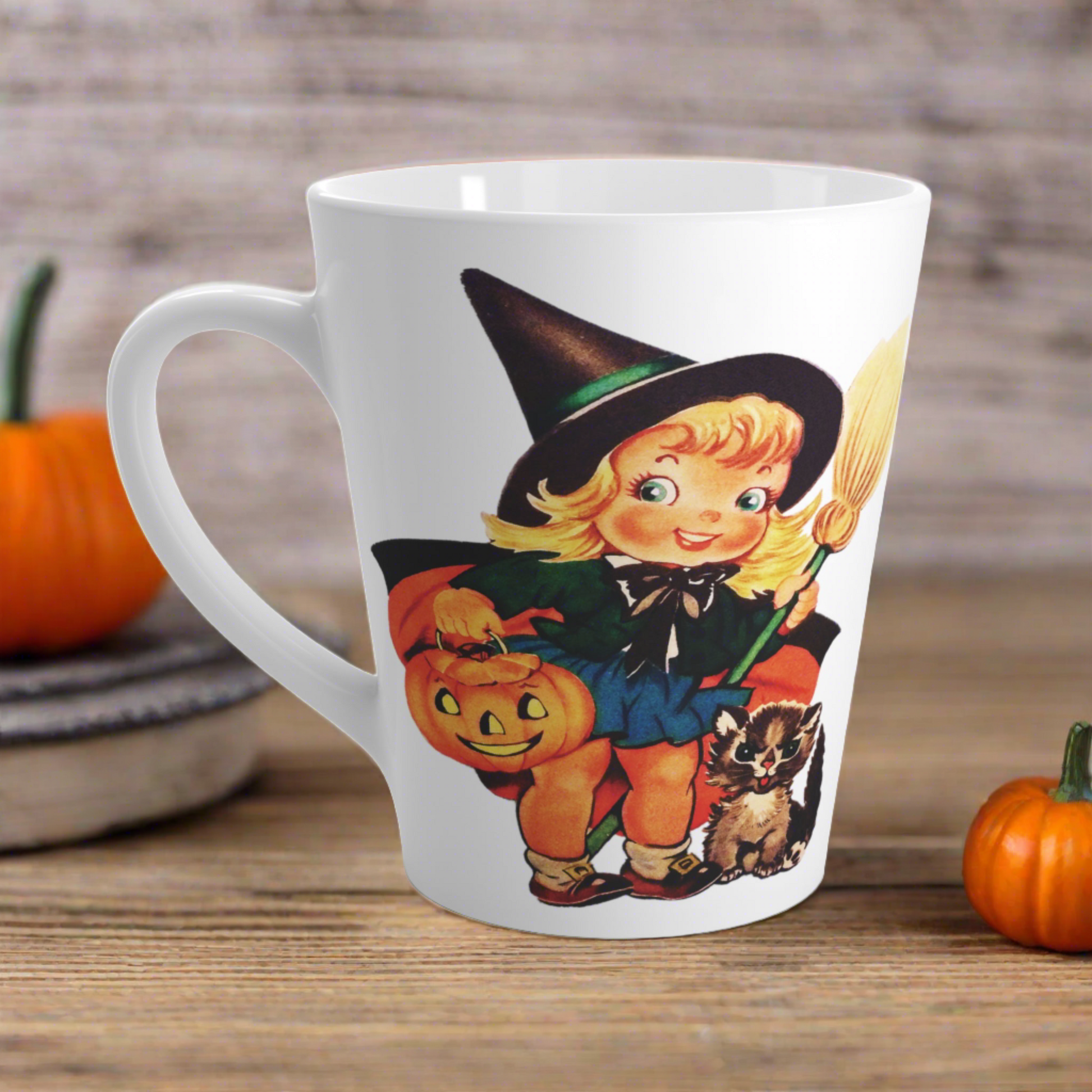 This ceramic glossy latte coffee cup features a retro vintage Halloween print of a young witch holding a broom and jack o lantern with a little brown cat sitting next to her.