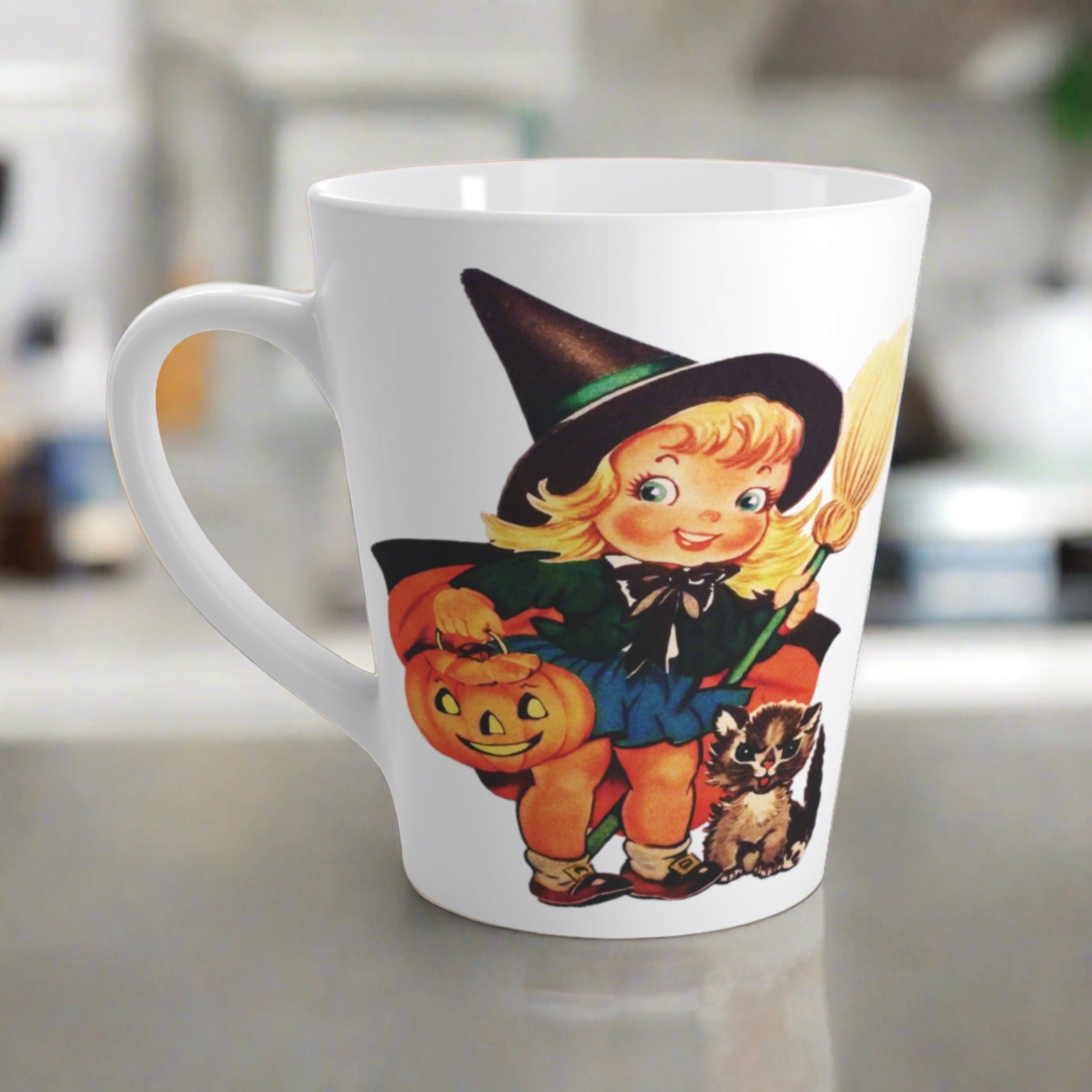 This ceramic glossy latte coffee cup features a retro vintage Halloween print of a young witch holding a broom and jack o lantern with a little brown cat sitting next to her.