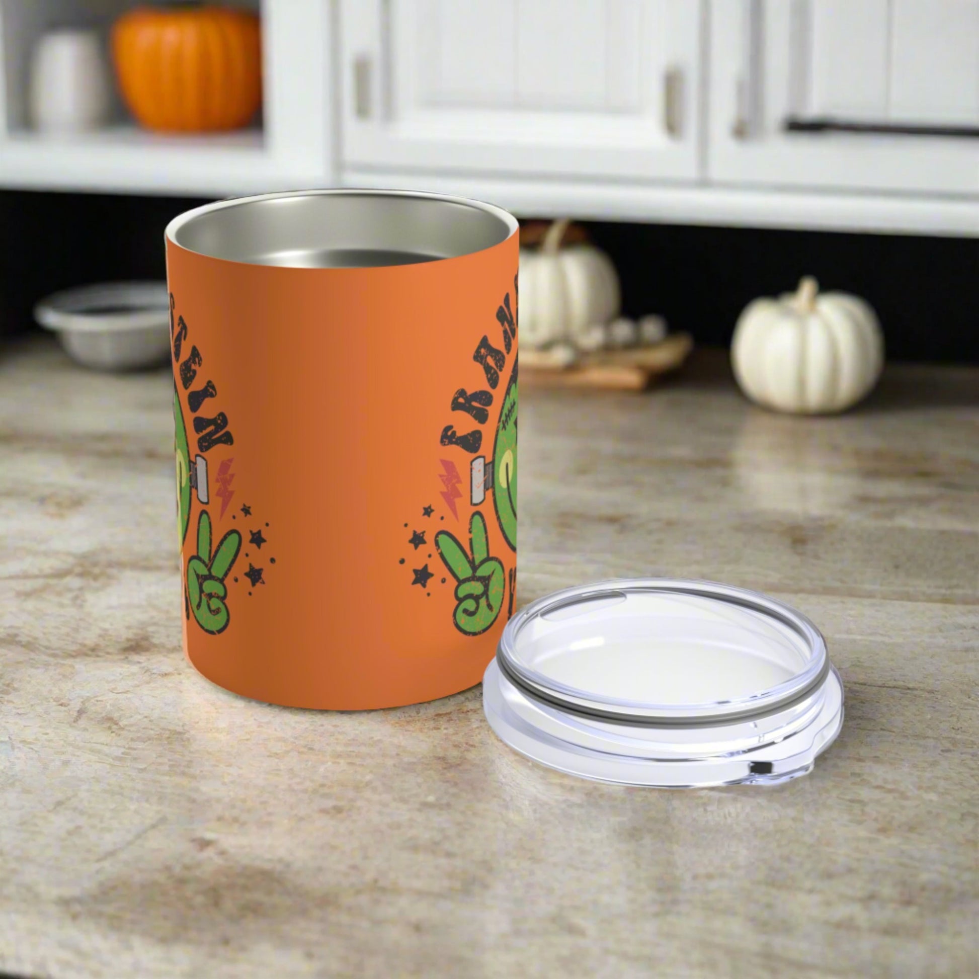 This 10 ounce orange stainless steel travel tumbler says Frankenstein Vibes and features a cute green monster smiley face with stars and lightning bolts.