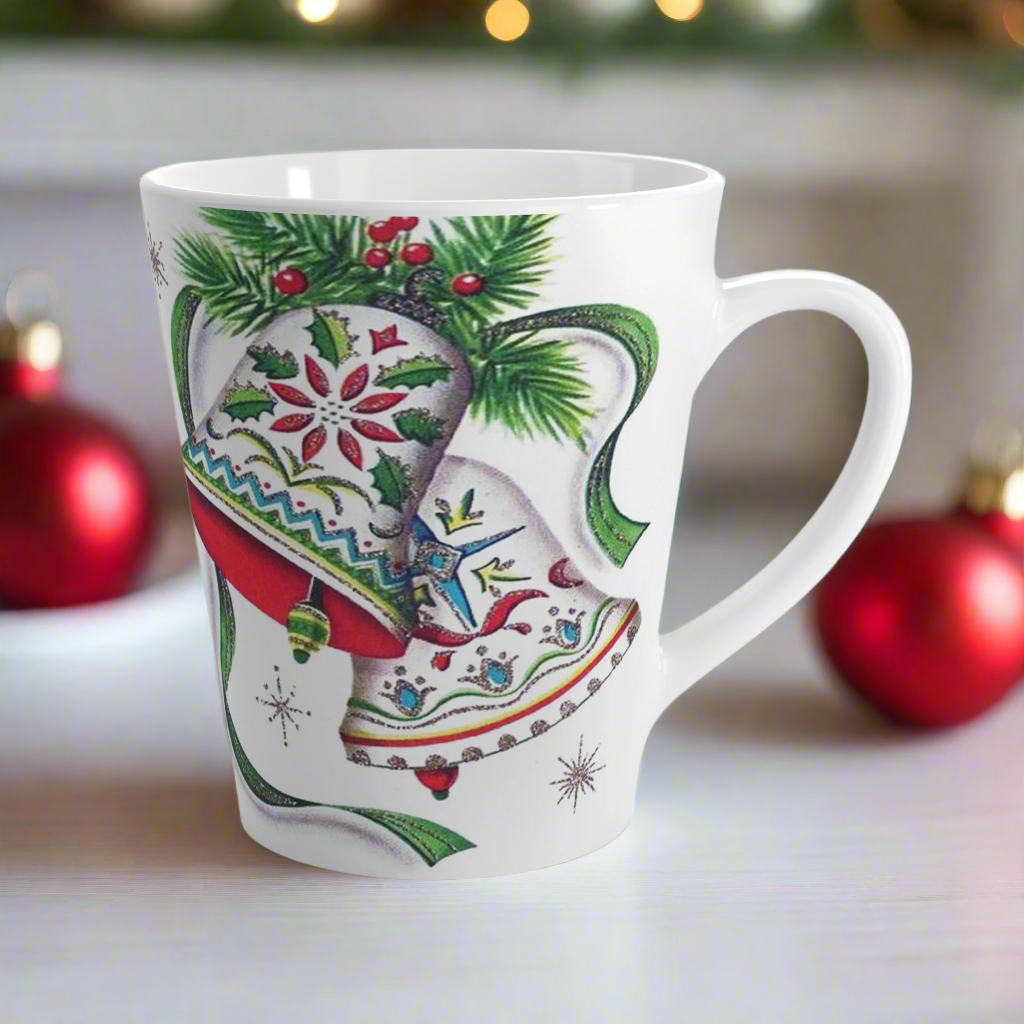 This ceramic glossy latte coffee cup features a vintage Christmas illustration of two holiday bells with ribbon, pine and berries. The design on the bells is reminiscent of European Scandinavian Christmas decorations.