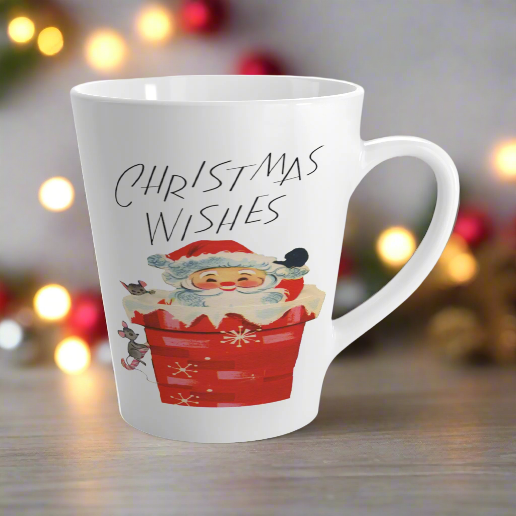 This glossy ceramic latte coffee mug says Christmas Wishes and features a retro Midcentury illustration of Santa peeking out of a snowy chimney with two mice.