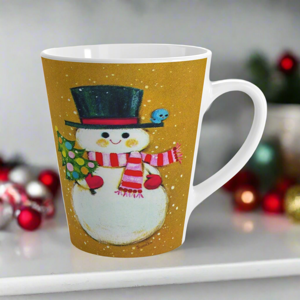 This ceramic latte coffee mug features an adorable retro mod Snowman. He is wearing a top hat and striped scarf, red gloves, and is holding a cute little christmas tree adorned with colorful round ornaments. There is a bluebird perched on his hat brim. It is an adorable mug perfect for gifting.