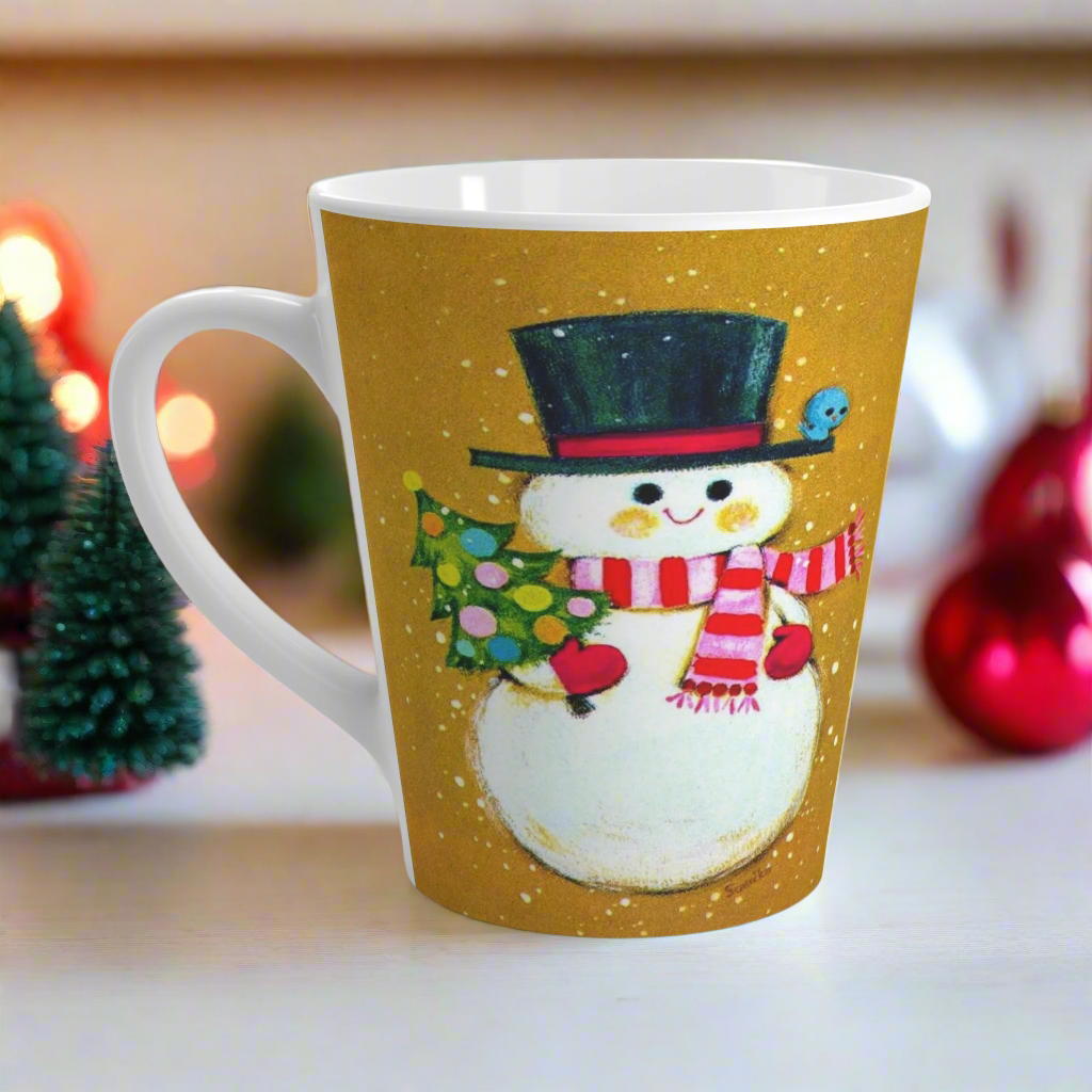 This ceramic latte coffee mug features an adorable retro mod Snowman. He is wearing a top hat and striped scarf, red gloves, and is holding a cute little christmas tree adorned with colorful round ornaments. There is a bluebird perched on his hat brim. It is an adorable mug perfect for gifting.