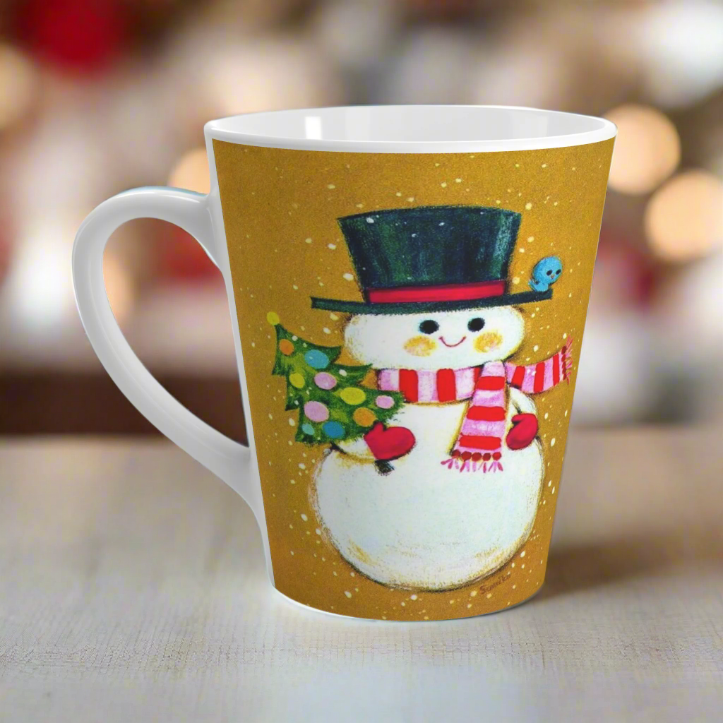 This ceramic latte coffee mug features an adorable retro mod Snowman. He is wearing a top hat and striped scarf, red gloves, and is holding a cute little christmas tree adorned with colorful round ornaments. There is a bluebird perched on his hat brim. It is an adorable mug perfect for gifting.