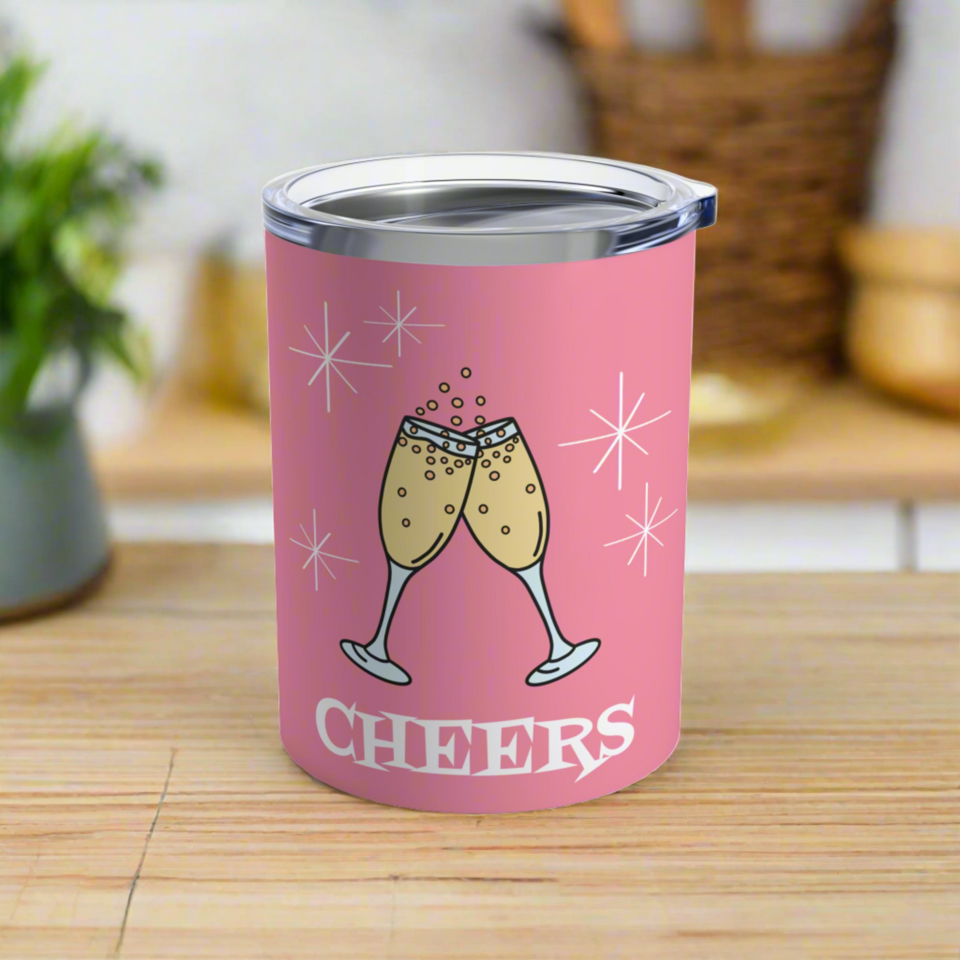 This 10 ounce pink stainless steel tumbler features two toasting champagne glasses with little bubbles. There is atomic era stars and lettering that says Cheers. It comes with a plastic sipping lid.