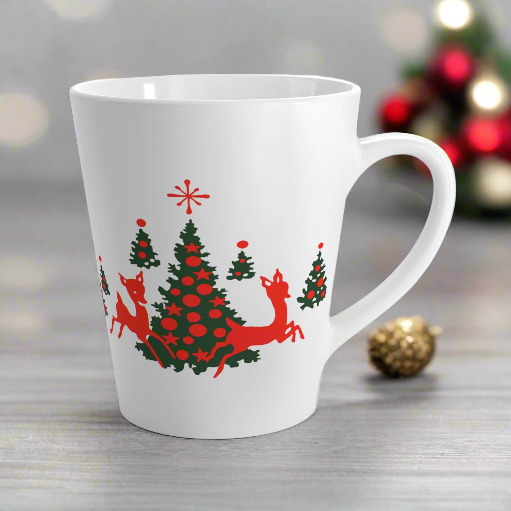 This ceramic glossy latte coffee mug features a midcentury retro illustration of red reindeer and green christmas trees with red ornaments.