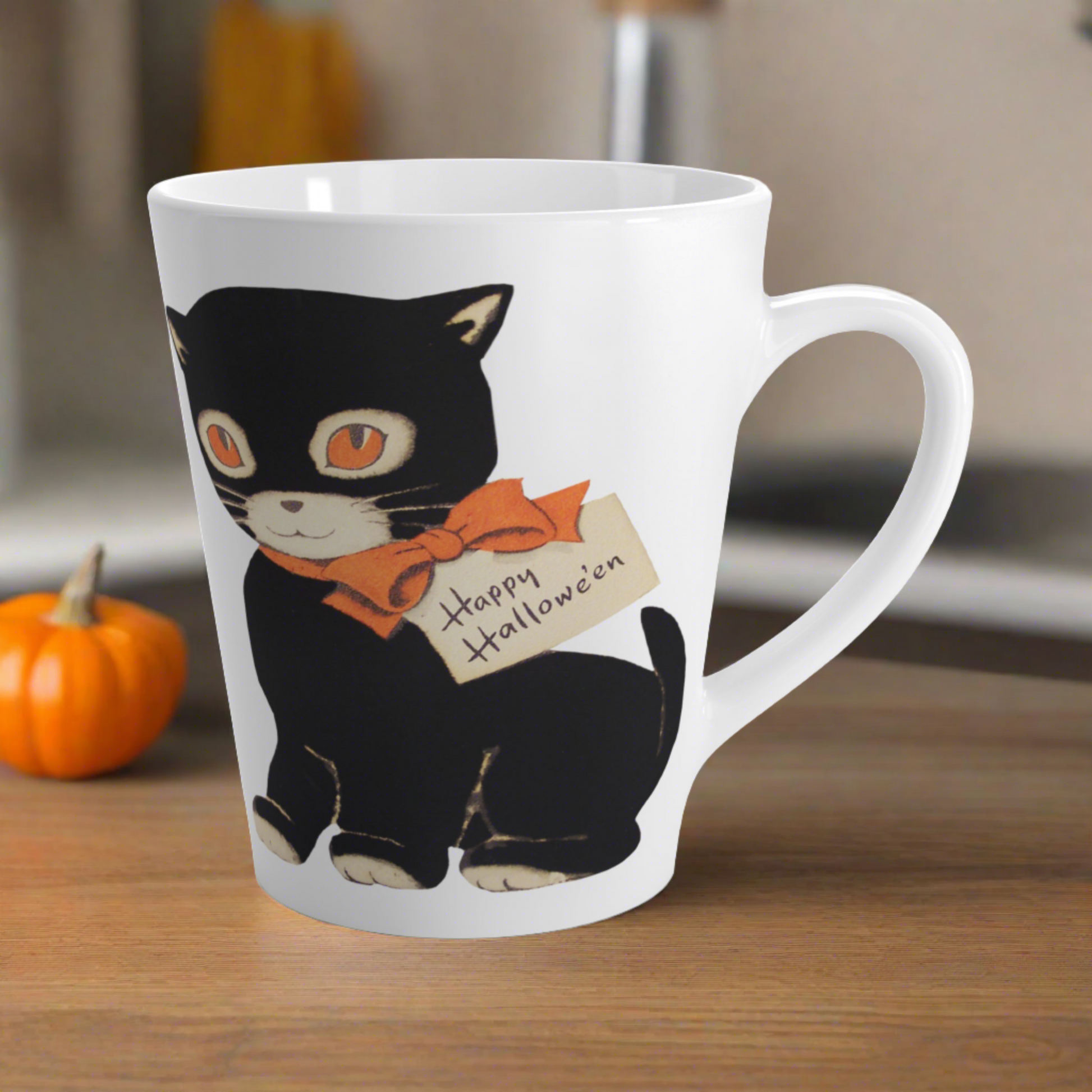 This glossy ceramic latte mug features a retro vintage Halloween illustration of a black cat with orange eyes. She is wearing an orange bow with a tag that says Happy Halloween.