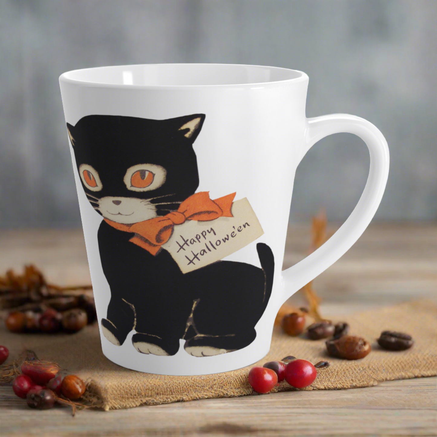 This glossy ceramic latte mug features a retro vintage Halloween illustration of a black cat with orange eyes. She is wearing an orange bow with a tag that says Happy Halloween.