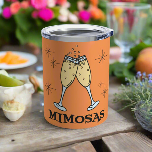 This orange 10 ounce stainless steel vacuum insulated tumbler mug features an atomic era style design of toasting champagne glasses with stars and the word Mimosas underneath the flutes.