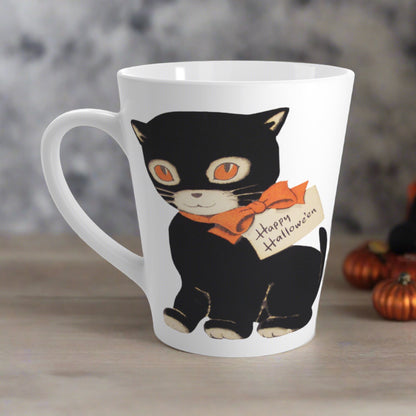 This glossy ceramic latte mug features a retro vintage Halloween illustration of a black cat with orange eyes. She is wearing an orange bow with a tag that says Happy Halloween.