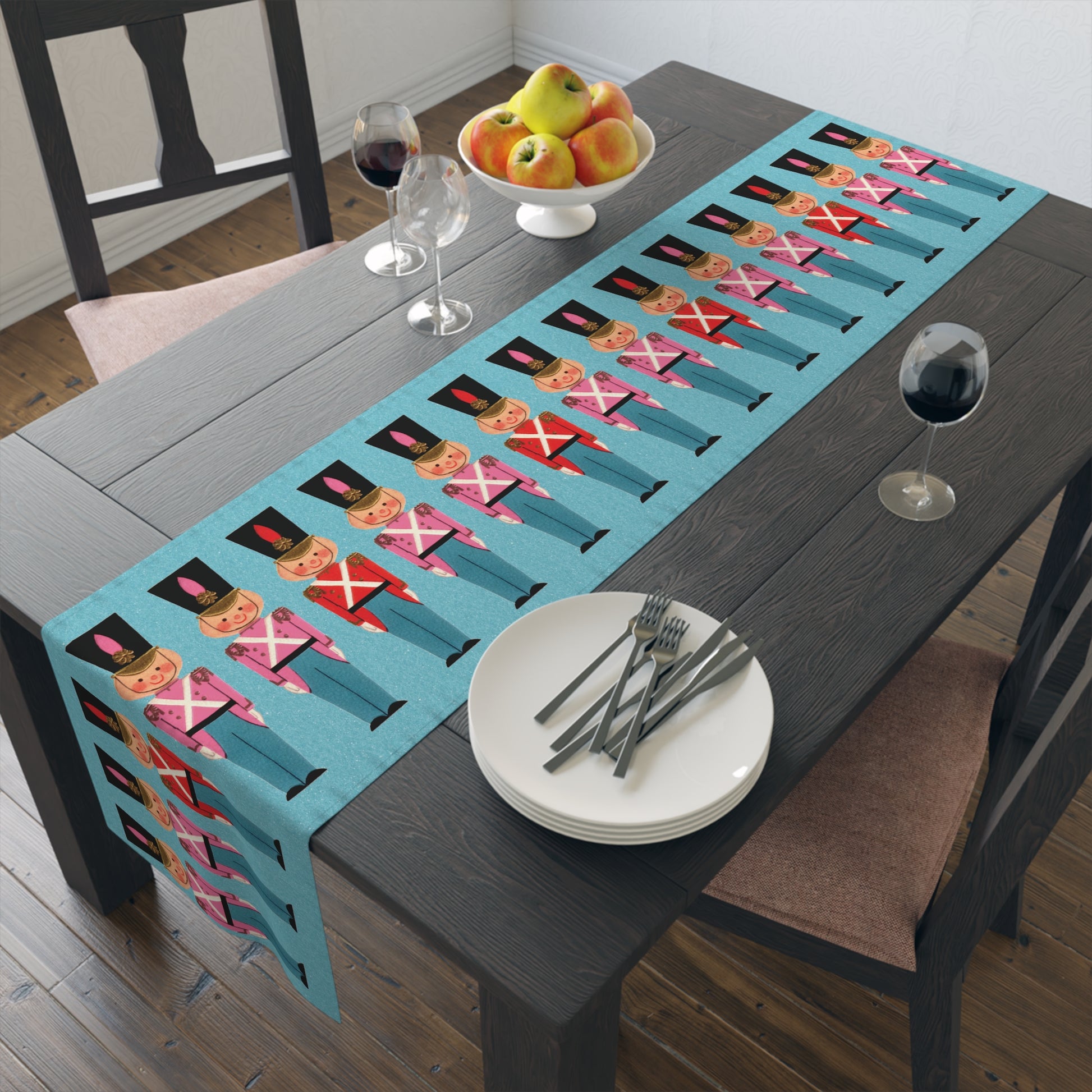 This blue fabric table runner features a Midcentury Christmas illustration of toy soldiers in red and white tops with a blue background. The blue is a retro felt background that shows little white sparkles.