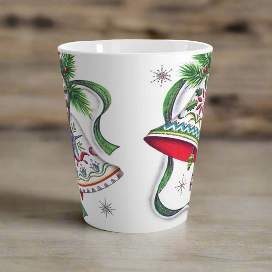 This ceramic glossy latte coffee cup features a vintage Christmas illustration of two holiday bells with ribbon, pine and berries. The design on the bells is reminiscent of European Scandinavian Christmas decorations.