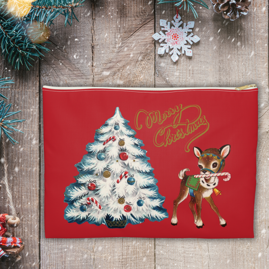 This red accessory pouch travel bag features midcentury artwork of a white Christmas tree outlined in blue with a reindeer holding a candy cane in her house. There is gold lettering that says Merry Christmas.