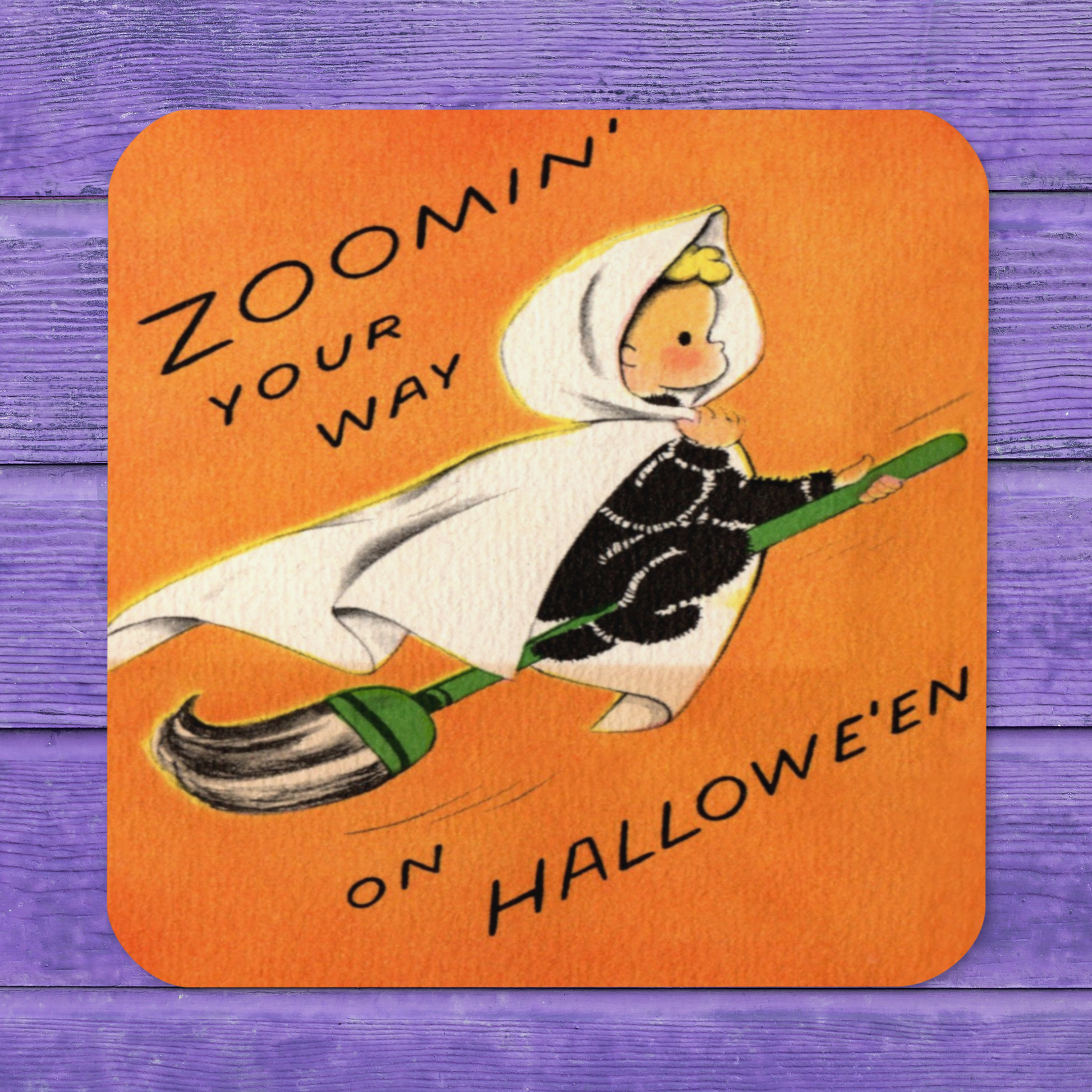 This orange glossy cork back coaster features a retro Halloween illustration that says Zoomin' Your Way On Halloween with an adorable witch flying on a broomstick.