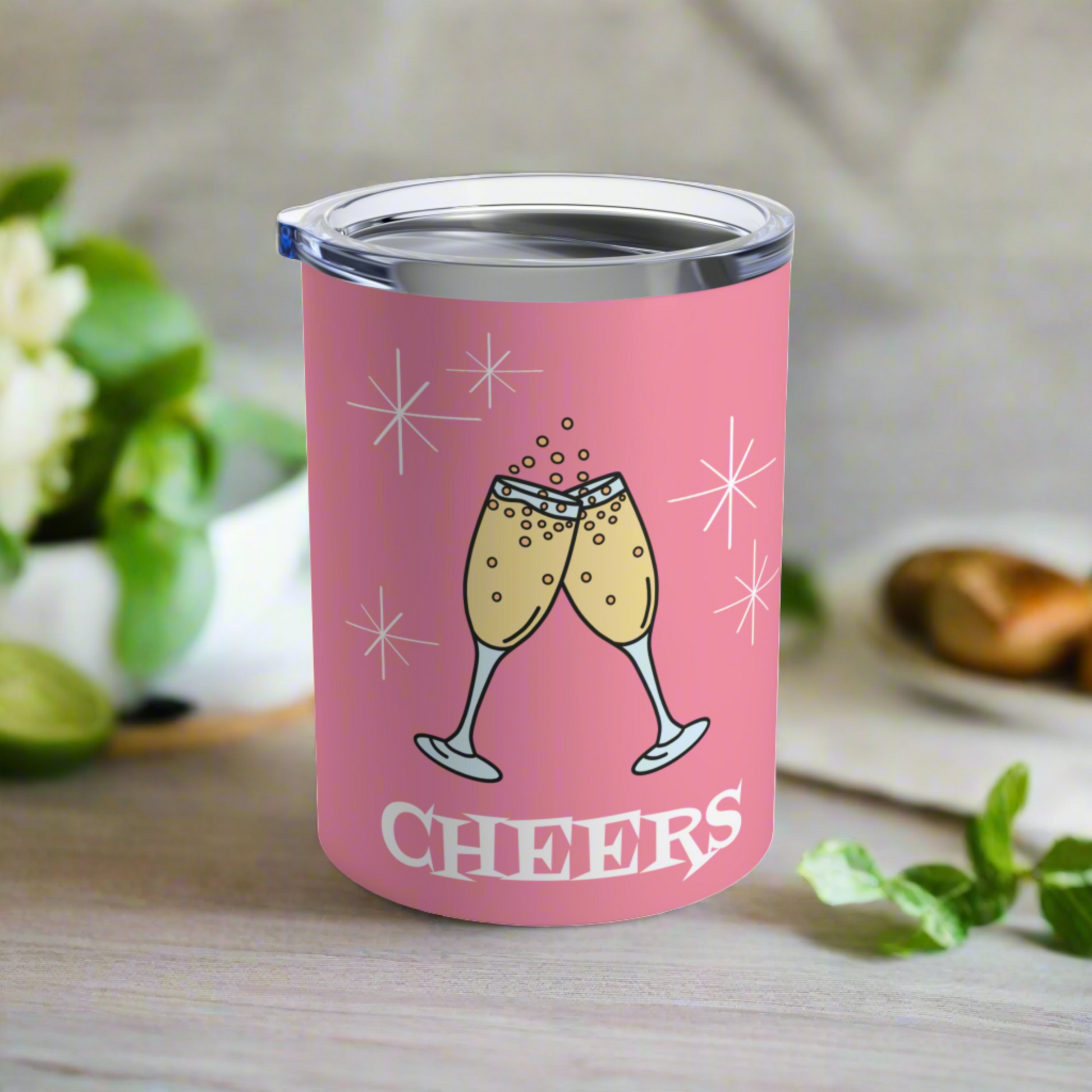 This 10 ounce pink stainless steel tumbler features two toasting champagne glasses with little bubbles. There is atomic era stars and lettering that says Cheers. It comes with a plastic sipping lid.