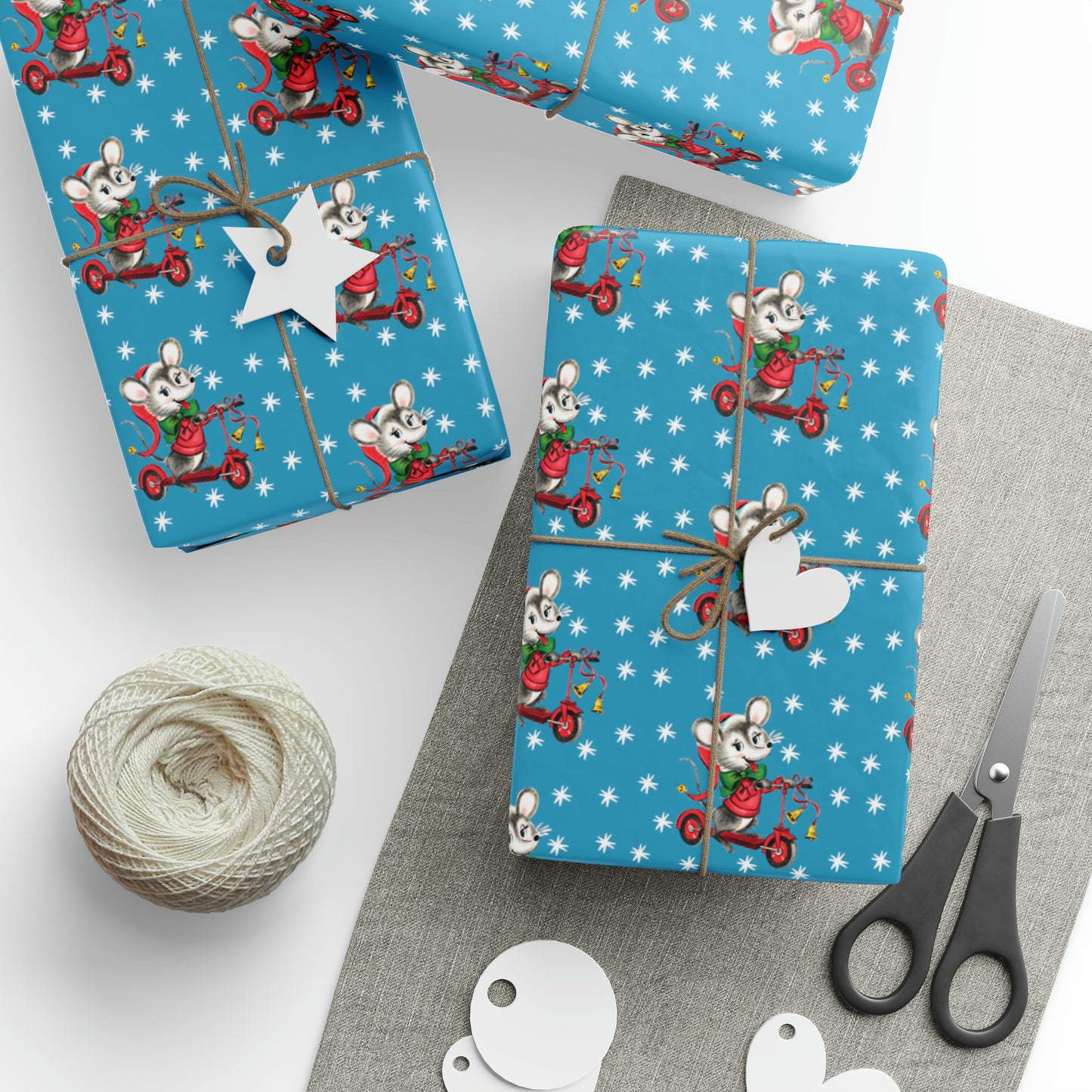 This Christmas gift wrap features a midcentury retro illustration of a cute mouse on a scooter wearing a Santa hat. The background is blue with white stars.