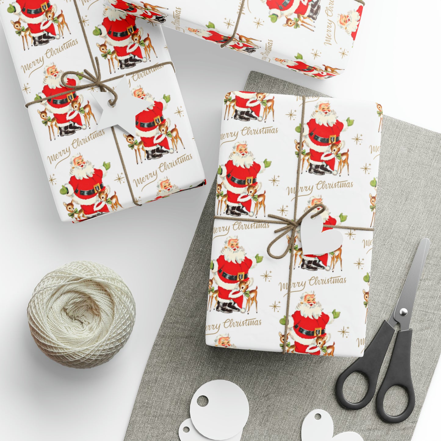 This white Christmas wrapping paper features a midcentury vintage illustration of Santa with two baby reindeer. There are gold stars and lettering that says Merry Christmas.