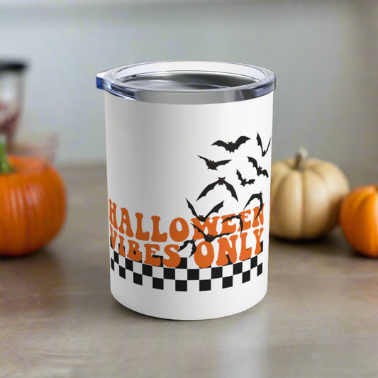 This 10 ounce stainless steel travel tumbler mug features orange retro lettering that says Halloween Vibes Only with black and white checkered print with flying bats. 