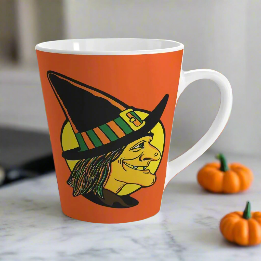 This 12 ounce ceramic latte coffee mug features a midcentury retro Halloween print of a profile of a witch with a full yellow moon behind her.