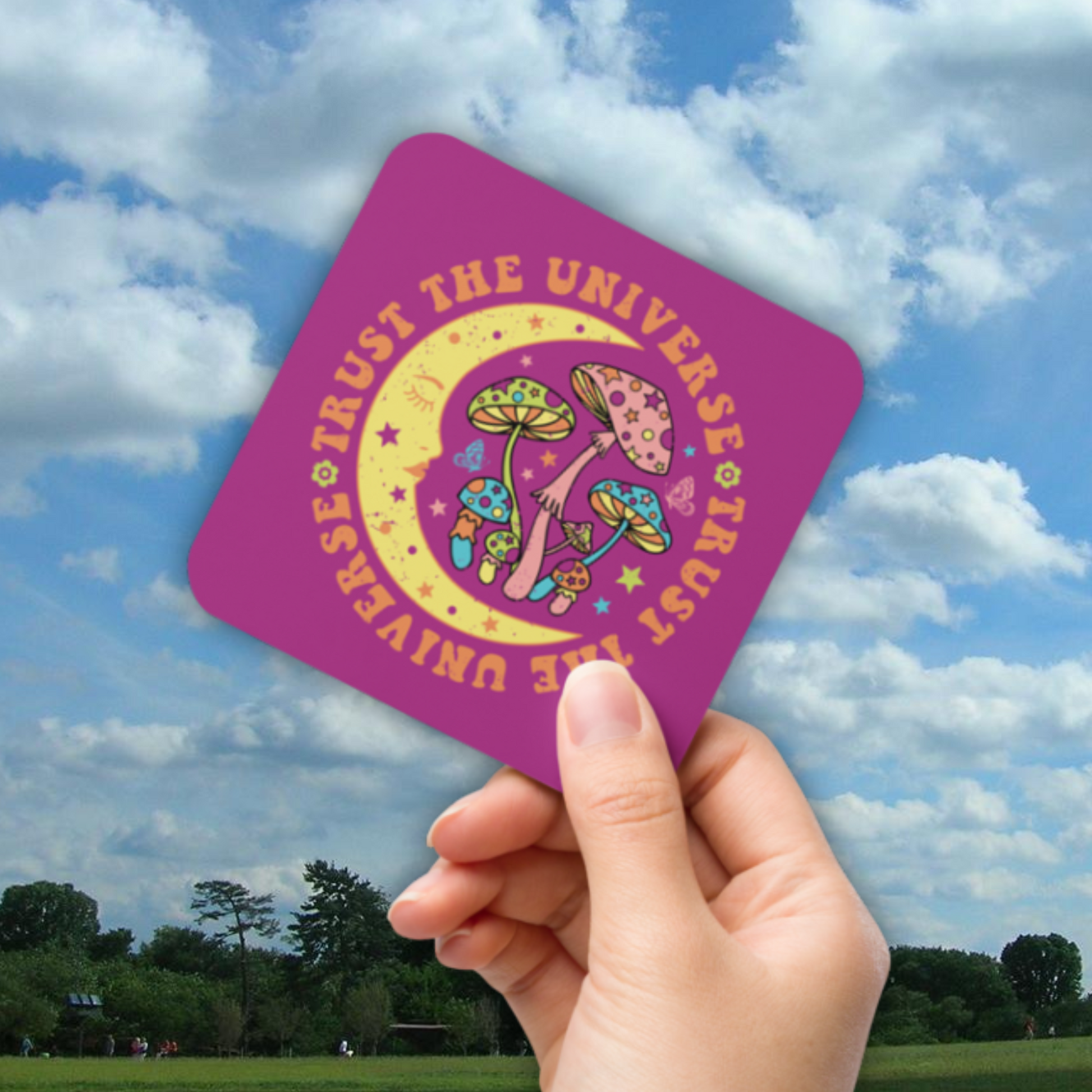 This glossy cork-back coaster says Trust The Universe in a retro style font. The coaster features the moon, mushrooms, stars, and butterflies.