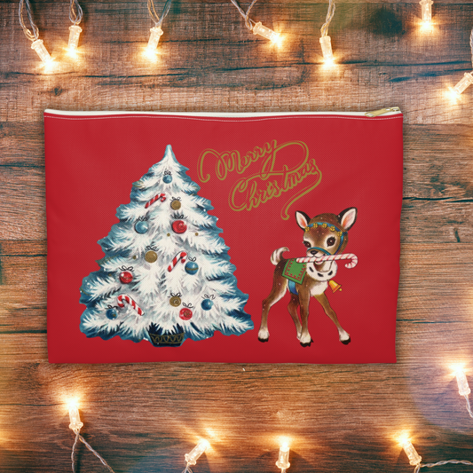 This red accessory pouch travel bag features midcentury artwork of a white Christmas tree outlined in blue with a reindeer holding a candy cane in her house. There is gold lettering that says Merry Christmas.