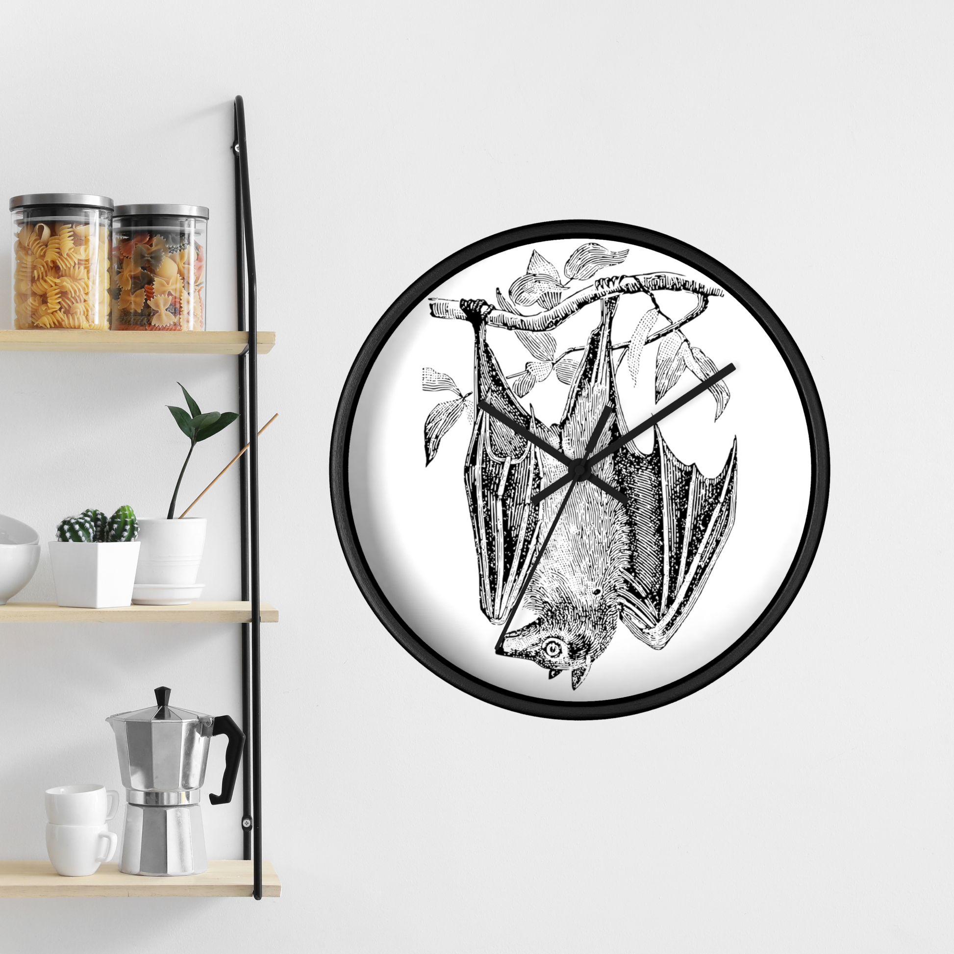 This black wall clock features a vintage illustration of a bat hanging upside down from a branch. The frame and hands of the clock are black.