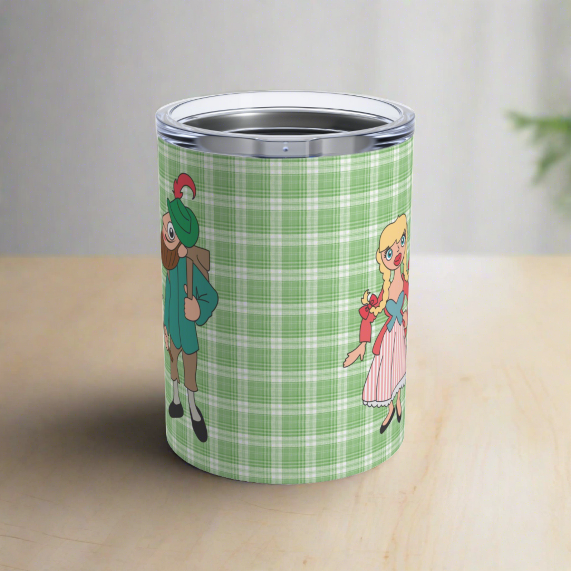 This 10 ounce travel tumbler mug features characters from the Sound of Music Lonely Goatherd song: The Goatherd, the girl in the pale pink coat, and the baby goat. The background is green plaid. The mug comes with a plastic sipping lid.