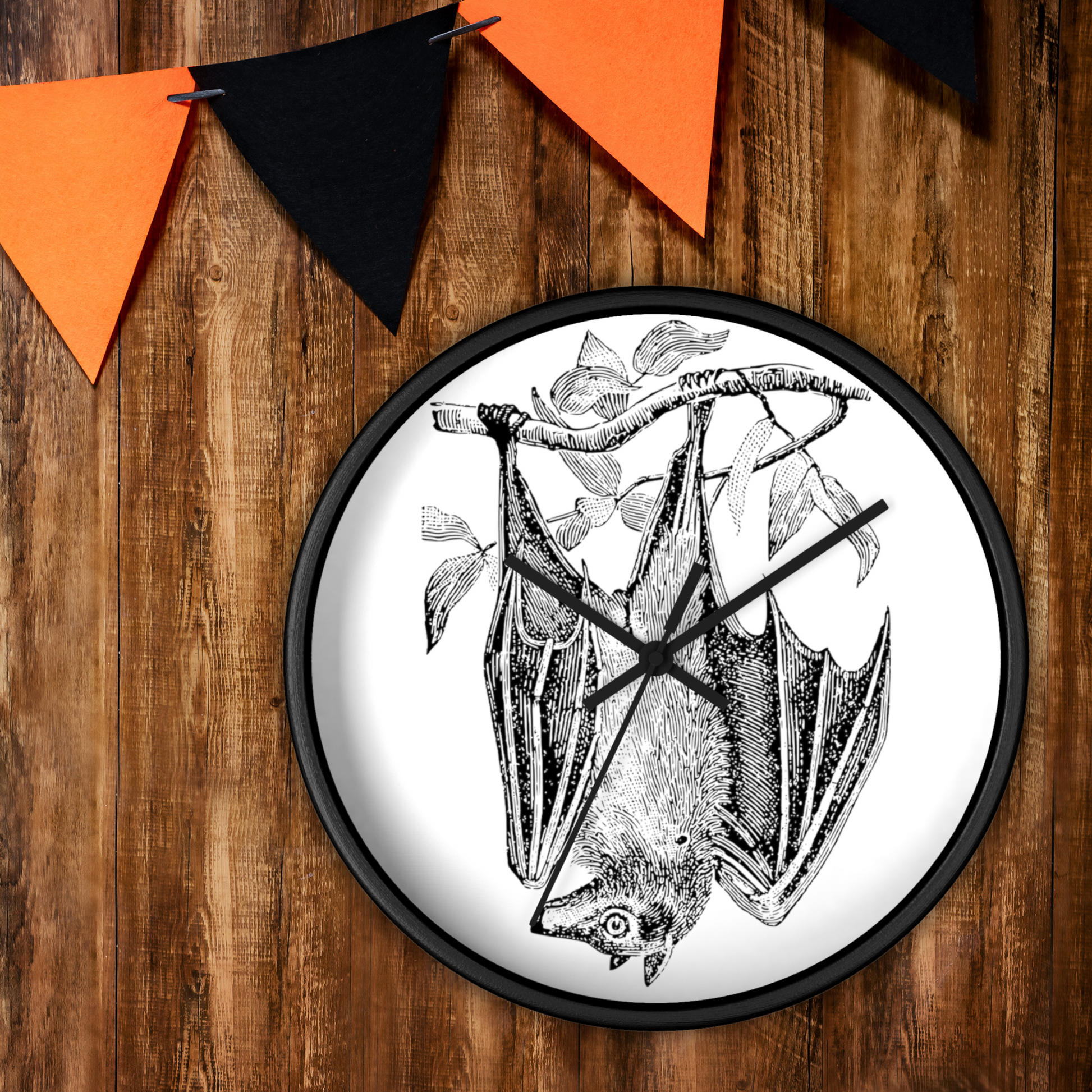 This black wall clock features a vintage illustration of a bat hanging upside down from a branch. The frame and hands of the clock are black.