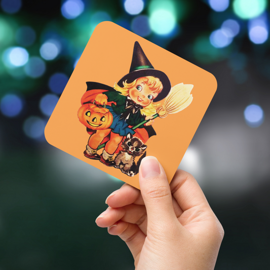 This glossy cork back coaster features an adorable retro Halloween illustration of a young witch holding a broom and jack o lantern with her brown cat sitting next to her.