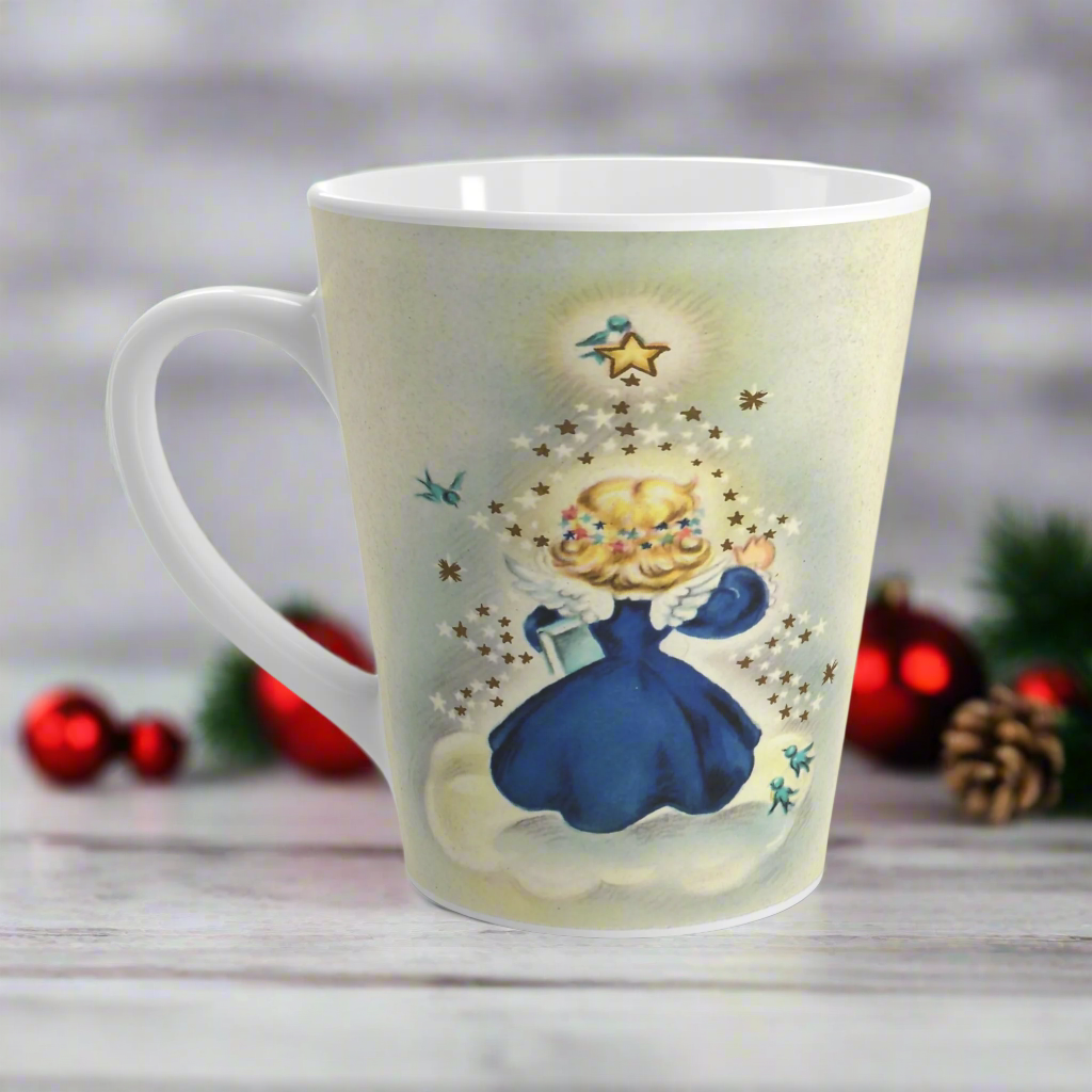 This ceramic glossy latte mug features an angel dressed in blue standing on a cloud. Her back is to us and you can see her wings. She is standing under a yellow star and bluebird. There are smaller white and blue stars and bluebirds surrounding her.