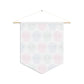 This pennant banner wall hanging features cute pastel goth skulls patterned in pink, green and blue with a white background on fabric canvas. It hands on a wooden dowel. The back is white.