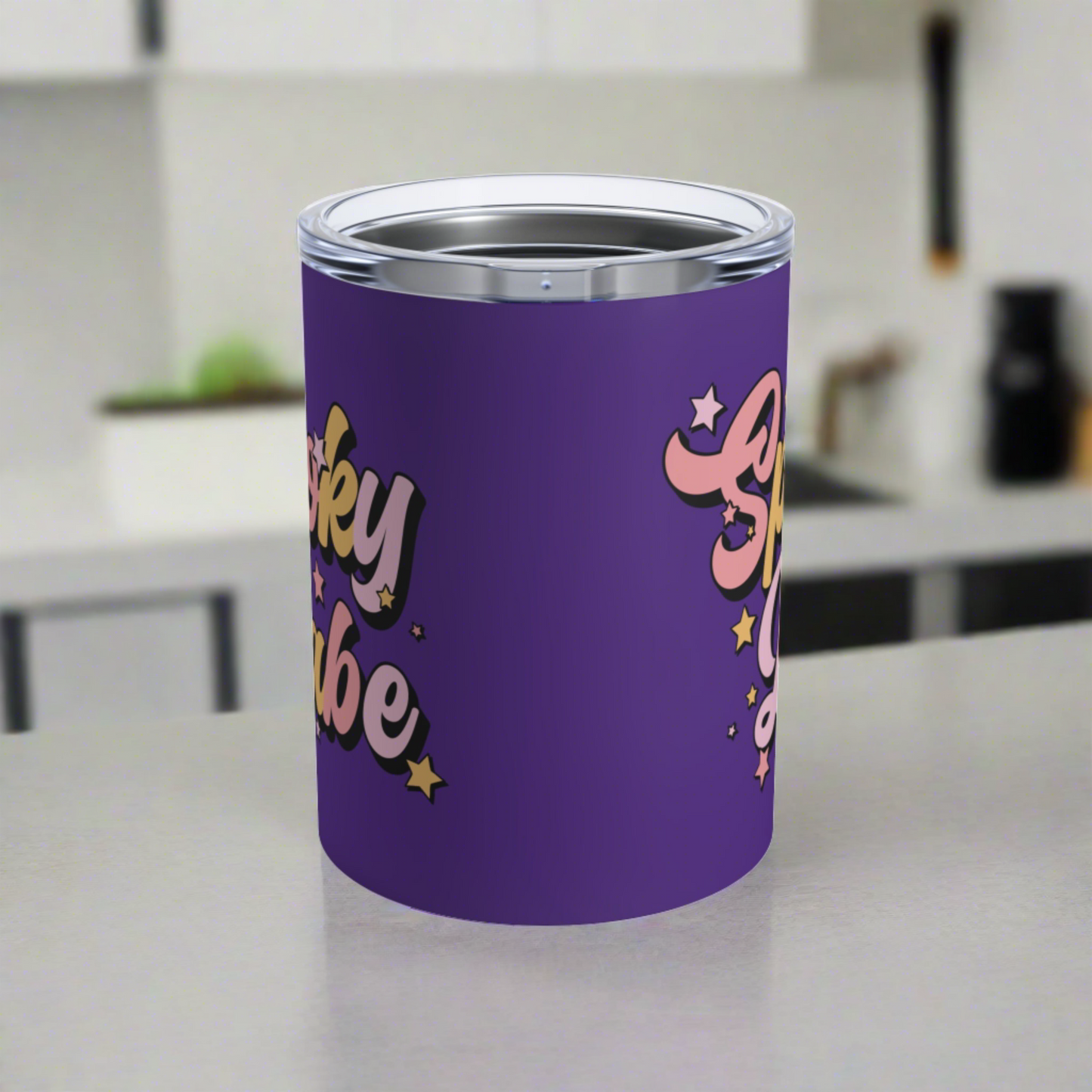 This 10 ounce purple stainless steel travel tumbler mug says Spooky Babe in pinks and yellows with stars.