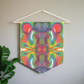 This fabric wall hanging features the hand drawn artwork of modern artist Caden Caraco. There are swirls of green, red, orange, yellows and purples. Original artwork is oil pastel on paper.