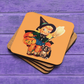 This glossy cork back coaster features an adorable retro Halloween illustration of a young witch holding a broom and jack o lantern with her brown cat sitting next to her.