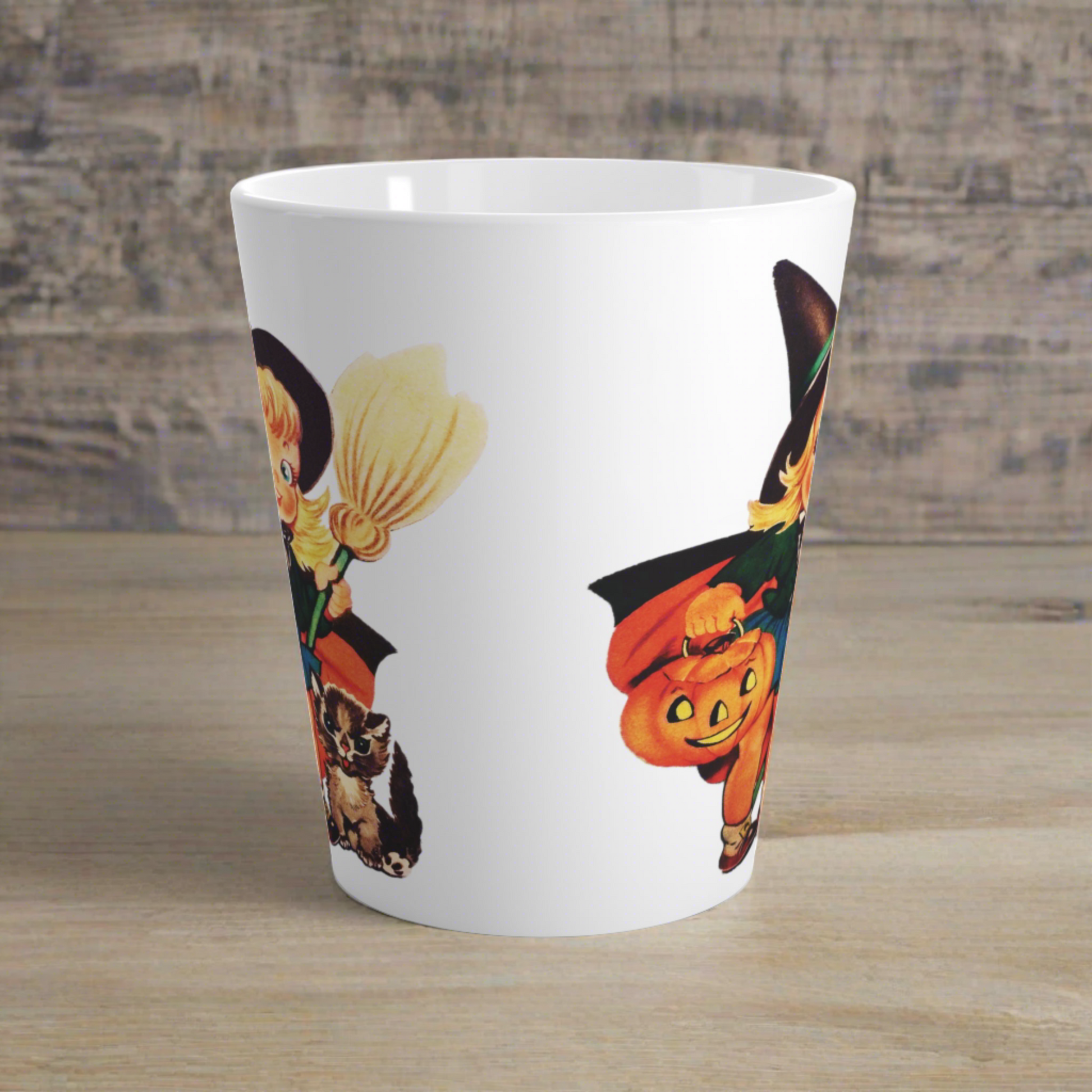 This ceramic glossy latte coffee cup features a retro vintage Halloween print of a young witch holding a broom and jack o lantern with a little brown cat sitting next to her.