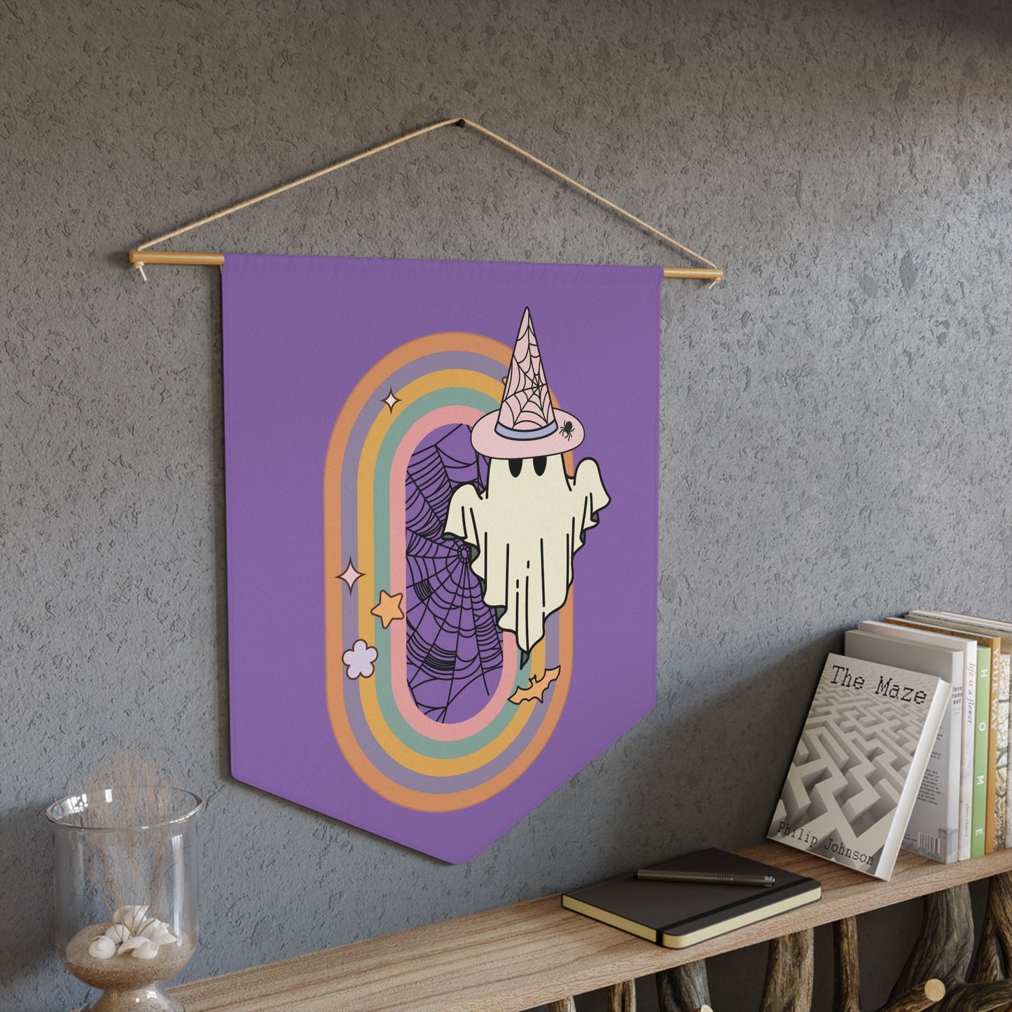 This purple pennant banner flag wall hanging features a retro boho pastel gothic style print of a ghost wearing a witch hat with a rainbow and spider web.