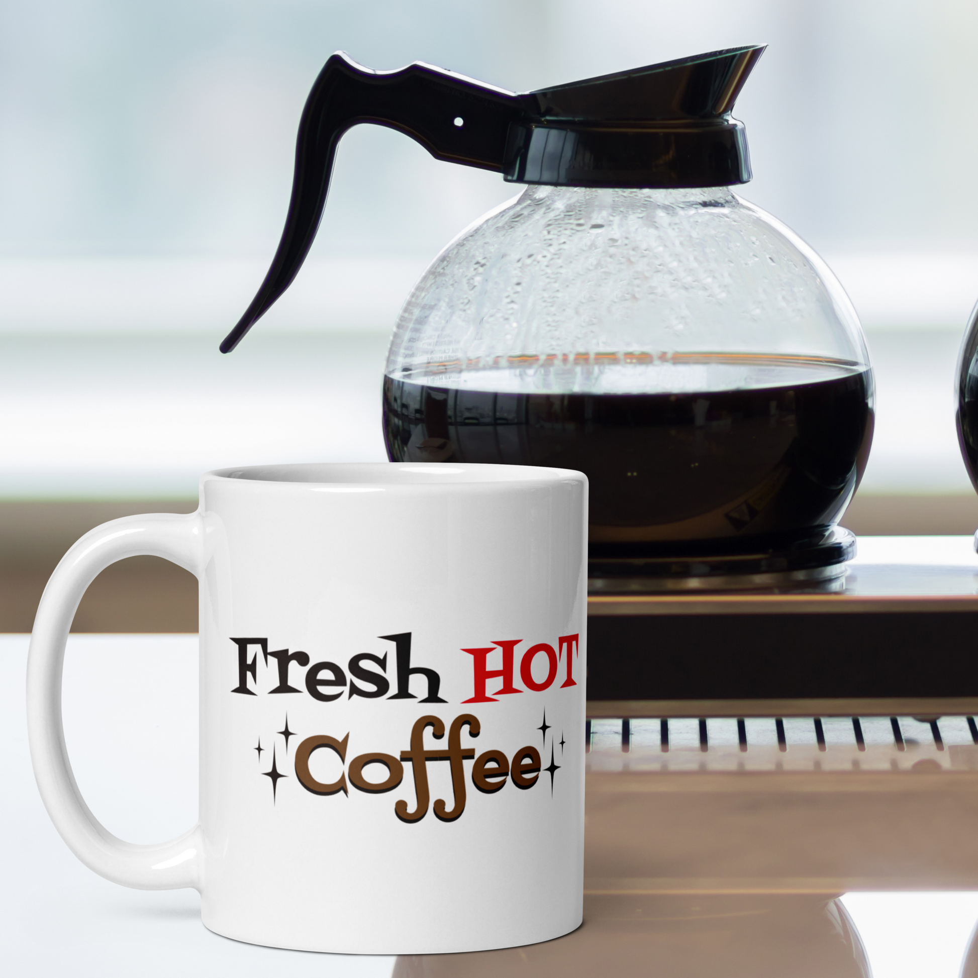 The ceramic white glossy mug features atomic era lettering that says Fresh HOT Coffee with starbursts around the word coffee. Fresh lettering is black, HOT is in red, and coffee is brown with a black shadowing.