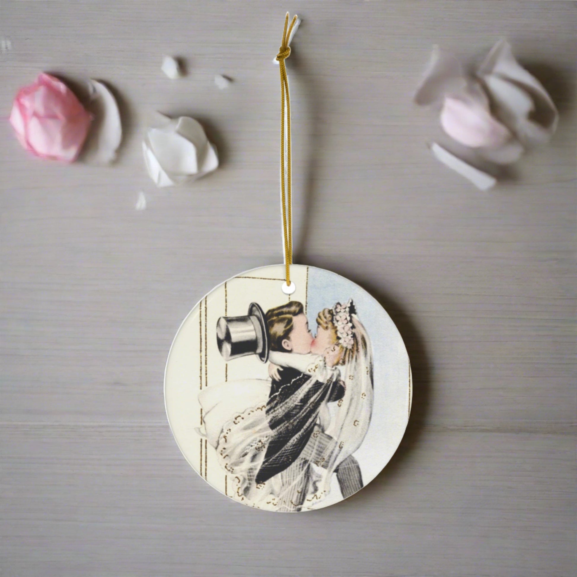 This round ceramic ornament features a vintage wedding illustration of a bride carrying his groom over the threshold while they share a kiss.