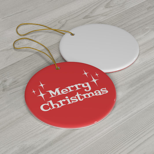 This round ceramic ornament is red with white atomic era style lettering that says Merry Christmas with three starbursts on each side.