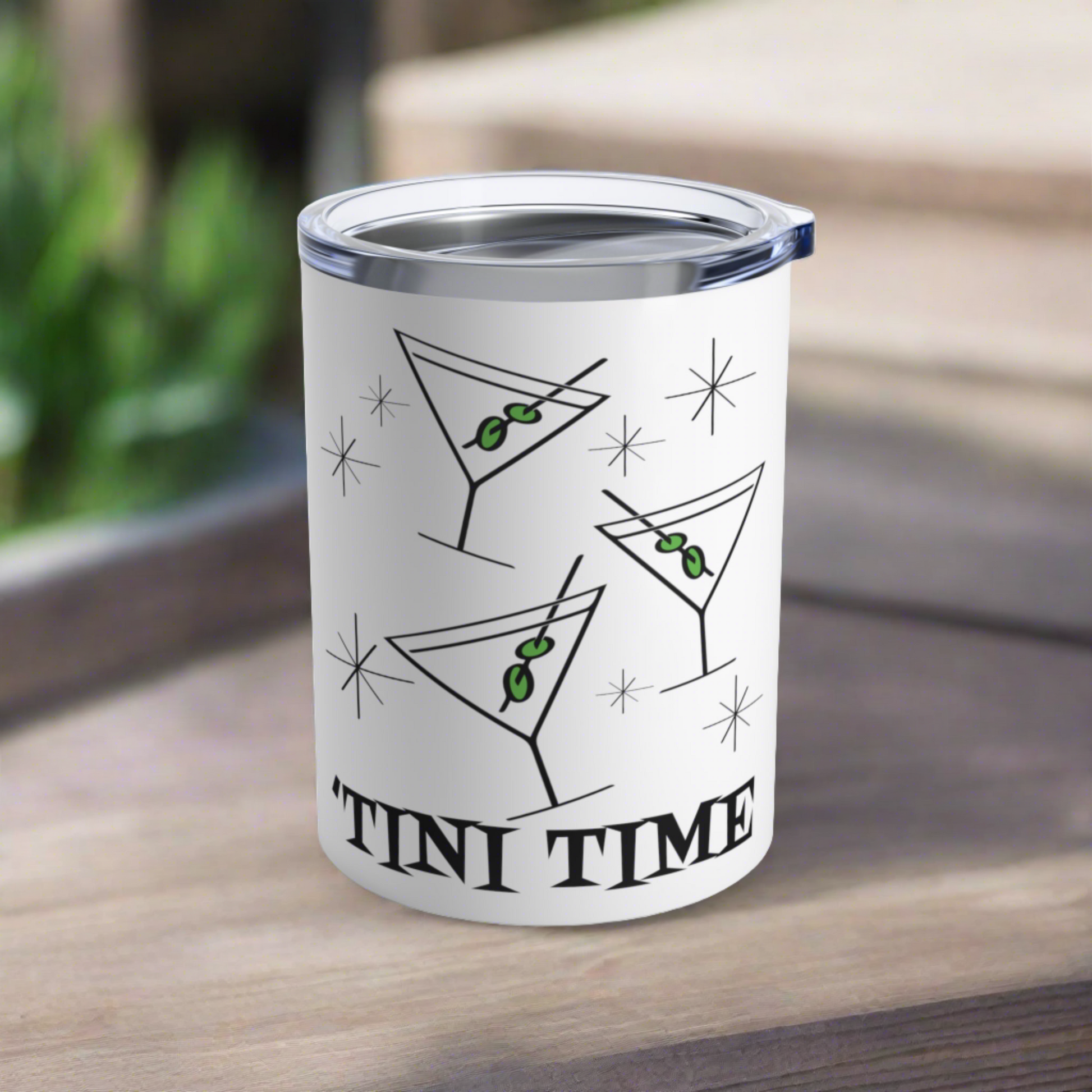 This 10 ounce white stainless steel tumbler features three martini glasses with green olives on toothpicks surrounded by stars and at the bottom the words say Tini Time in Atomic Retro Style lettering.