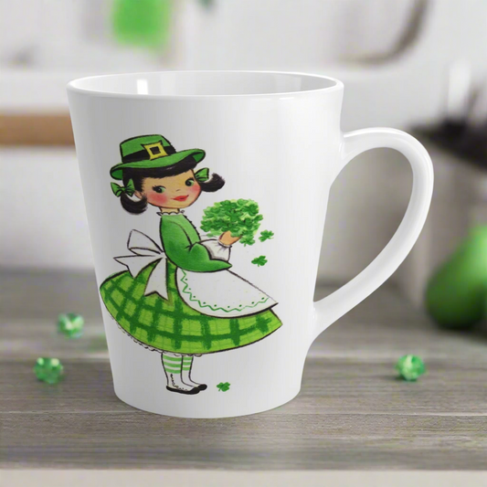 This ceramic glossy latte coffee mug features a midcentury St. Patrick's Day illustration of an adorable girl dresed in green holding a bouquet of shamrocks.