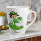 This ceramic glossy latte coffee mug features a midcentury St. Patrick's Day illustration of an adorable girl dresed in green holding a bouquet of shamrocks.