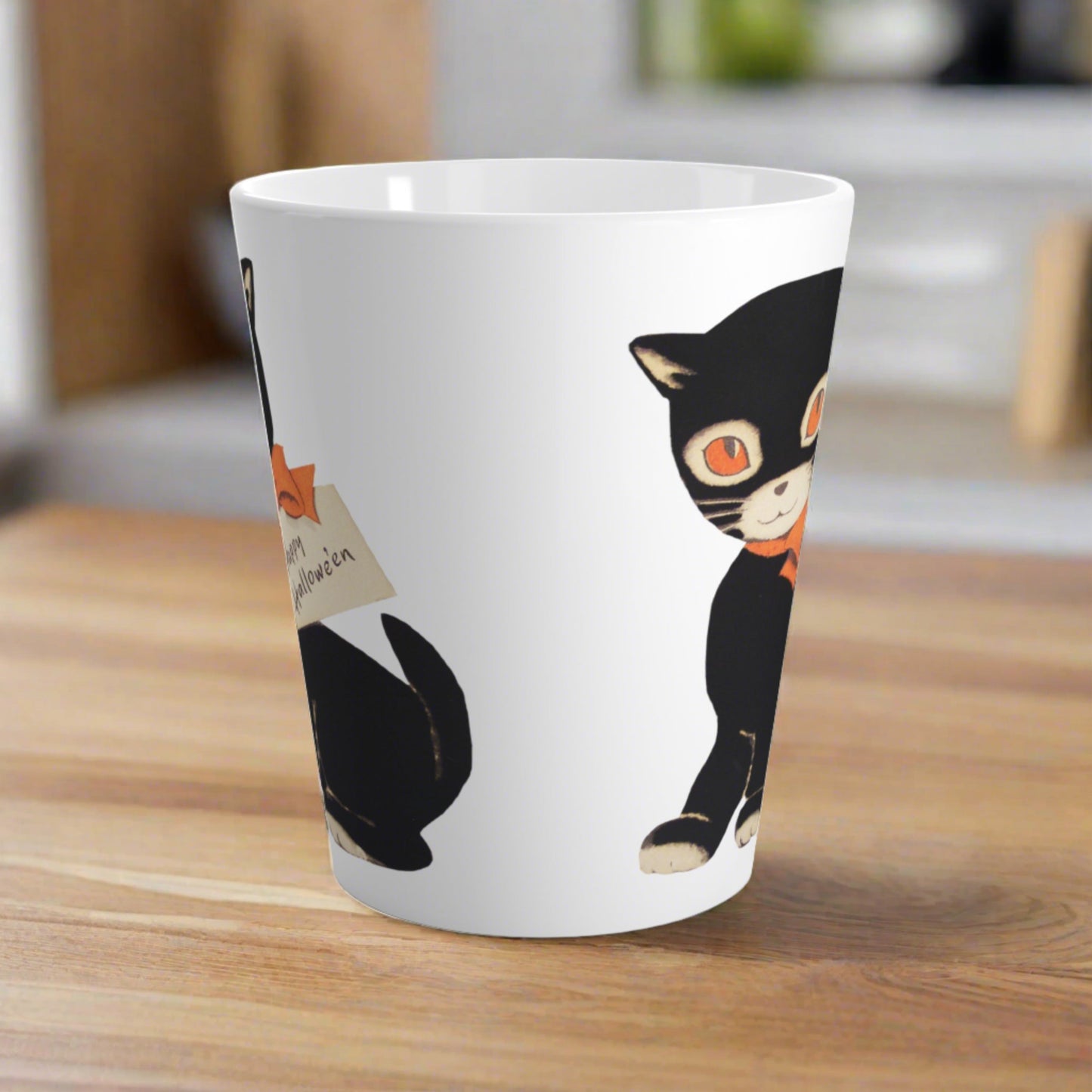 This glossy ceramic latte mug features a retro vintage Halloween illustration of a black cat with orange eyes. She is wearing an orange bow with a tag that says Happy Halloween.