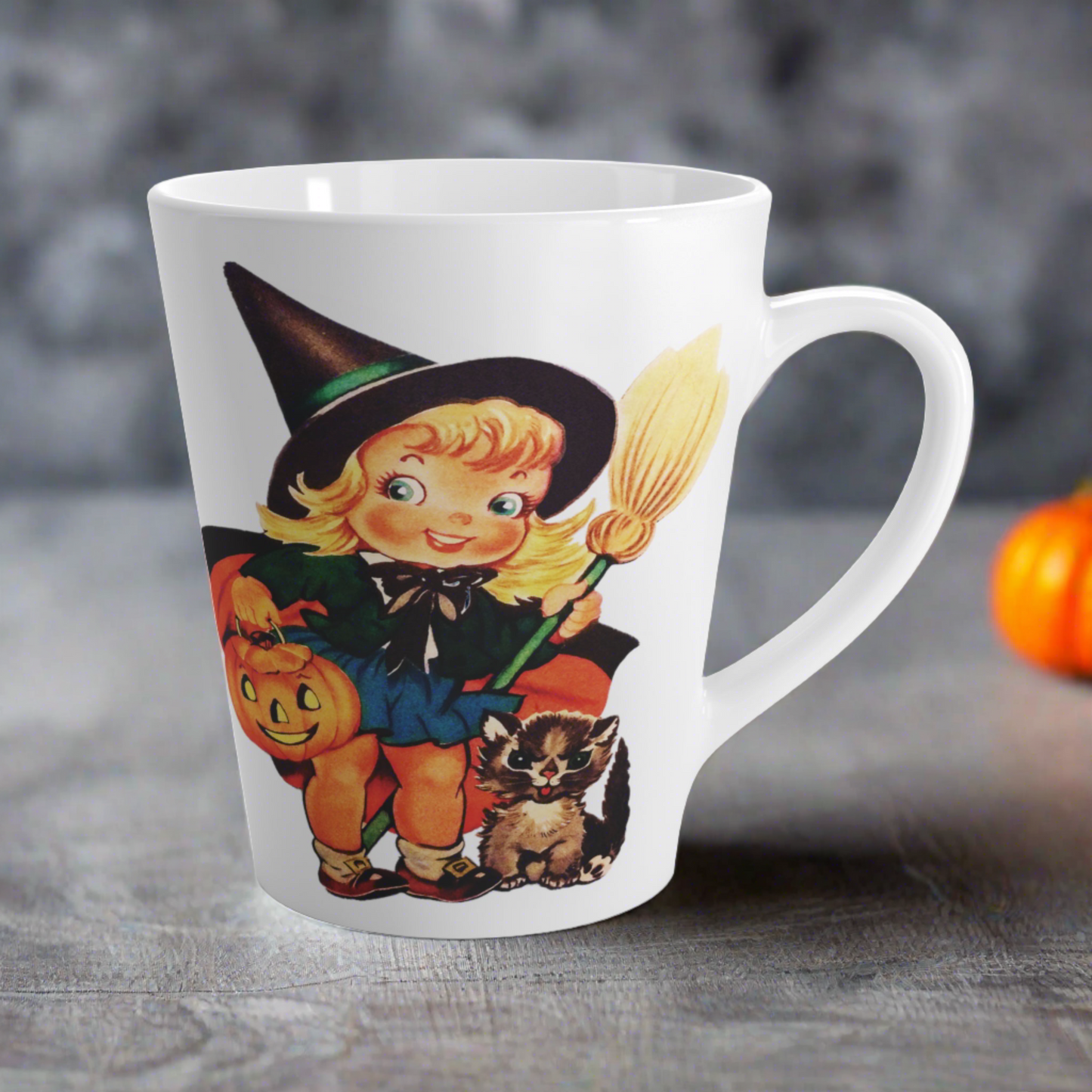 This ceramic glossy latte coffee cup features a retro vintage Halloween print of a young witch holding a broom and jack o lantern with a little brown cat sitting next to her.