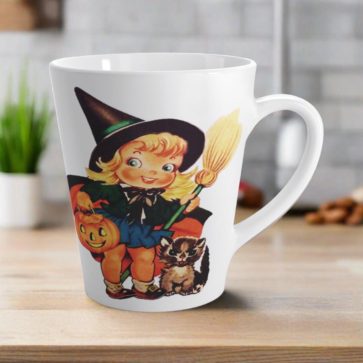 This ceramic glossy latte coffee cup features a retro vintage Halloween print of a young witch holding a broom and jack o lantern with a little brown cat sitting next to her.