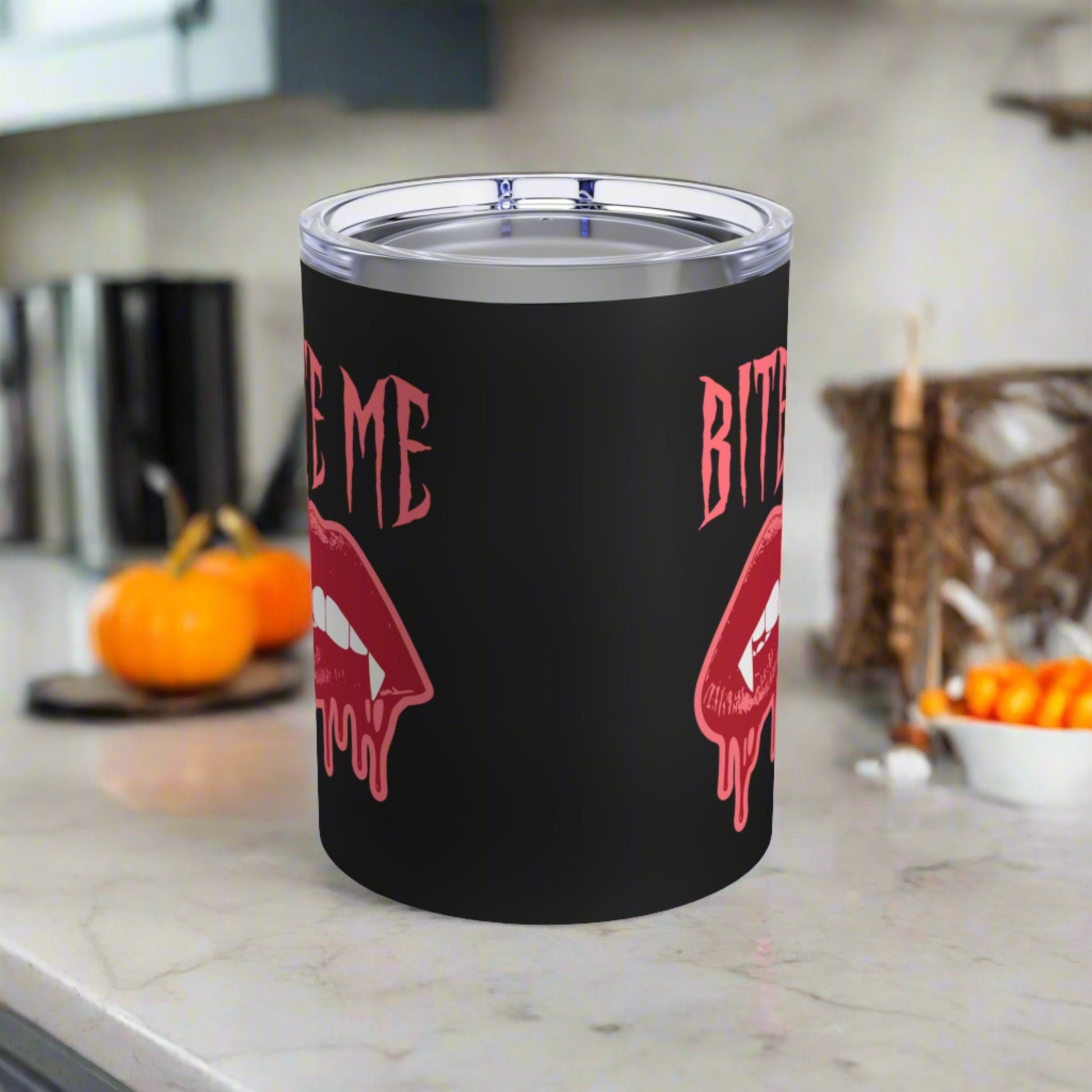 This 10 ounce stainless steel vacuum insulated black travel tumbler features vampire lips and fangs dripping with blood and the words Bite Me in Pink.