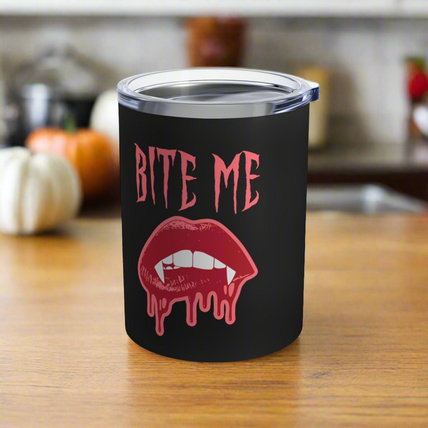 This 10 ounce stainless steel vacuum insulated black travel tumbler features vampire lips and fangs dripping with blood and the words Bite Me in Pink.